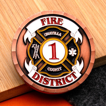 Umatilla County Fire District 1 copper challenge coin featuring a Maltese cross emblem.