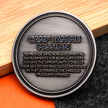 Antique silver challenge coin featuring the Camp I Am Me Mission statement engraved on the front face.