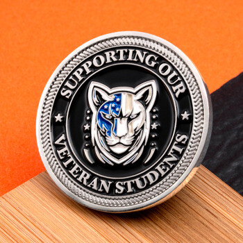 Circular challenge coin featuring a tiger emblem with an American flag accent and text reading Supporting Our Veteran Students.