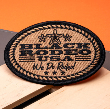 Oval embroidered patch featuring Black Rodeo USA text, stars, and rope border in black and tan thread.