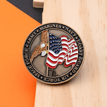 Circular challenge coin featuring an American flag, eagle, and the names of U.S. military branches around the border.