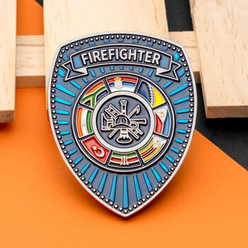 Shield-shaped challenge coin featuring the word Firefighter, a central gear with fire tools, and various international flags in a circular border.