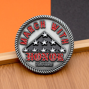 Antiqued silver challenge coin featuring a folded American flag design and red lettering that reads March With Honor Est. 1926.