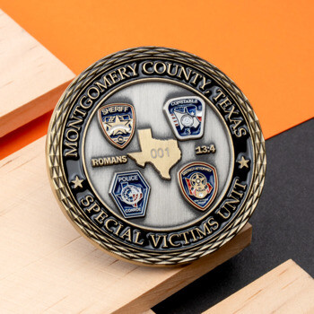Circular silver and black challenge coin for Montgomery County, Texas Special Victims Unit featuring four law enforcement badges and a Texas state map silhouett