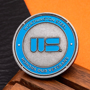 Worthington Steel Honors Our Veterans round challenge coin with blue enamel accents on a wooden base.