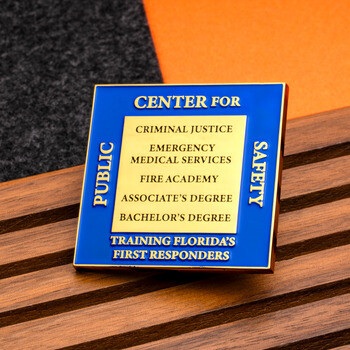 Square blue and gold challenge coin for the Center for Public Safety detailing first responder training programs.